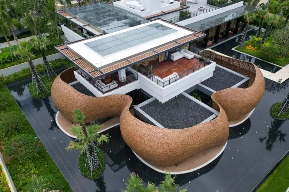 Woven bamboo pavilions surrounding a hotel building