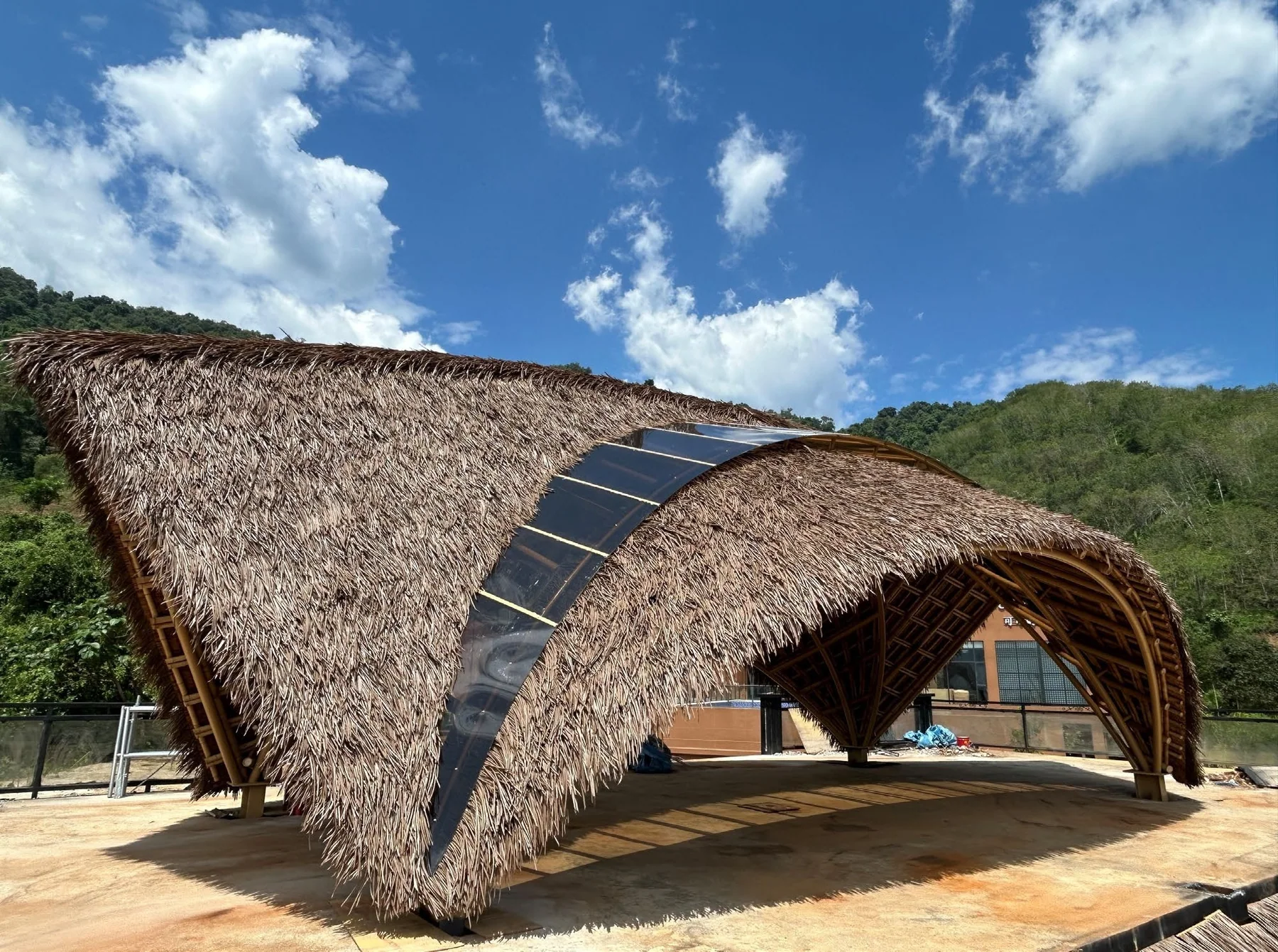 Curved bamboo and steel hybrid pavilion in a mountain setting